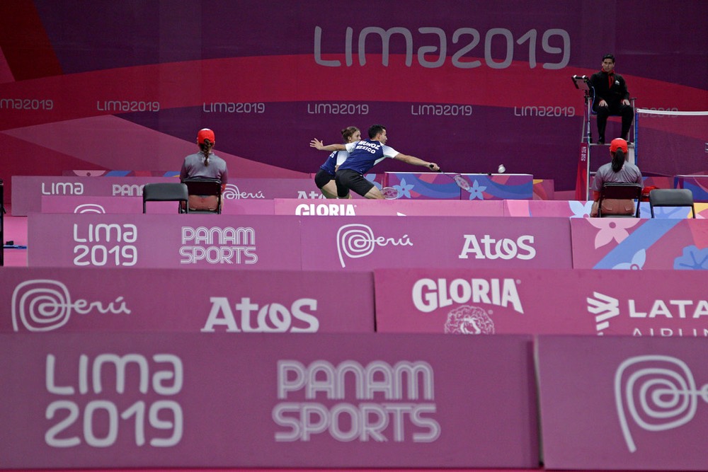 Wide view of a badminton match in an arena