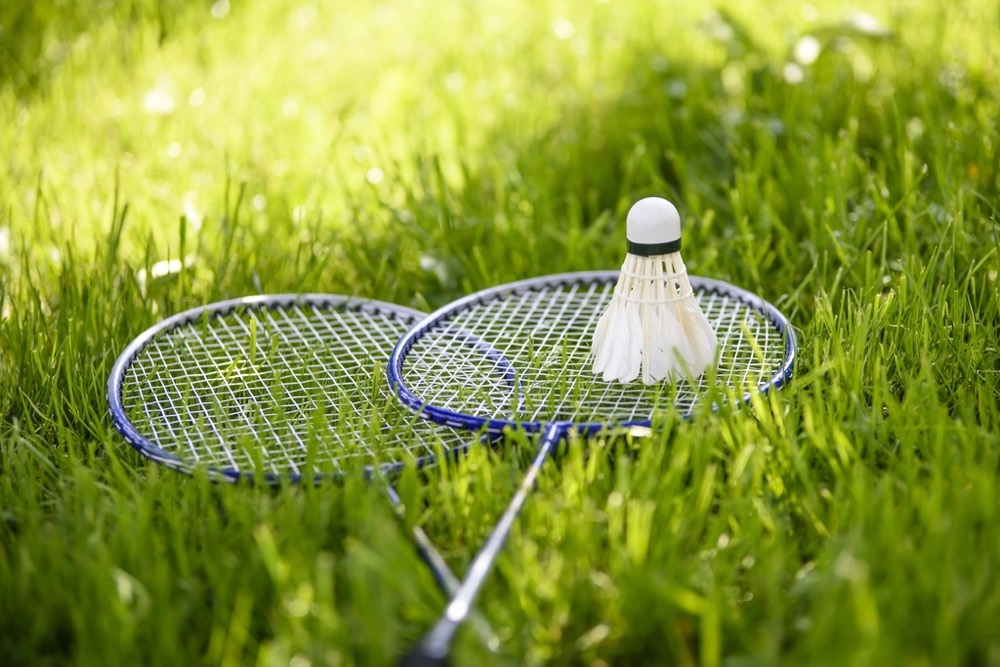 Two rackets and a shuttlecock on the grass