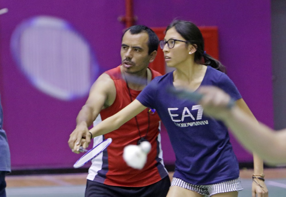 Mixed doubles pair playing a shot at the net