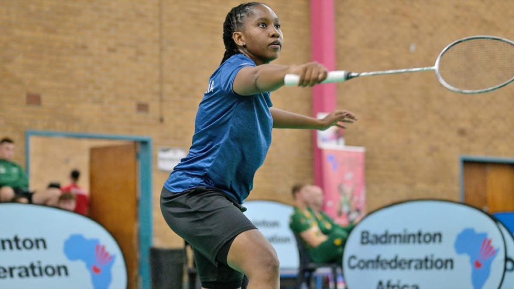 Player lunging forward to return a shuttle in a tournament