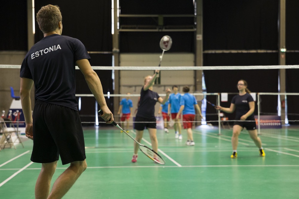 Players practising doubles in a training hall