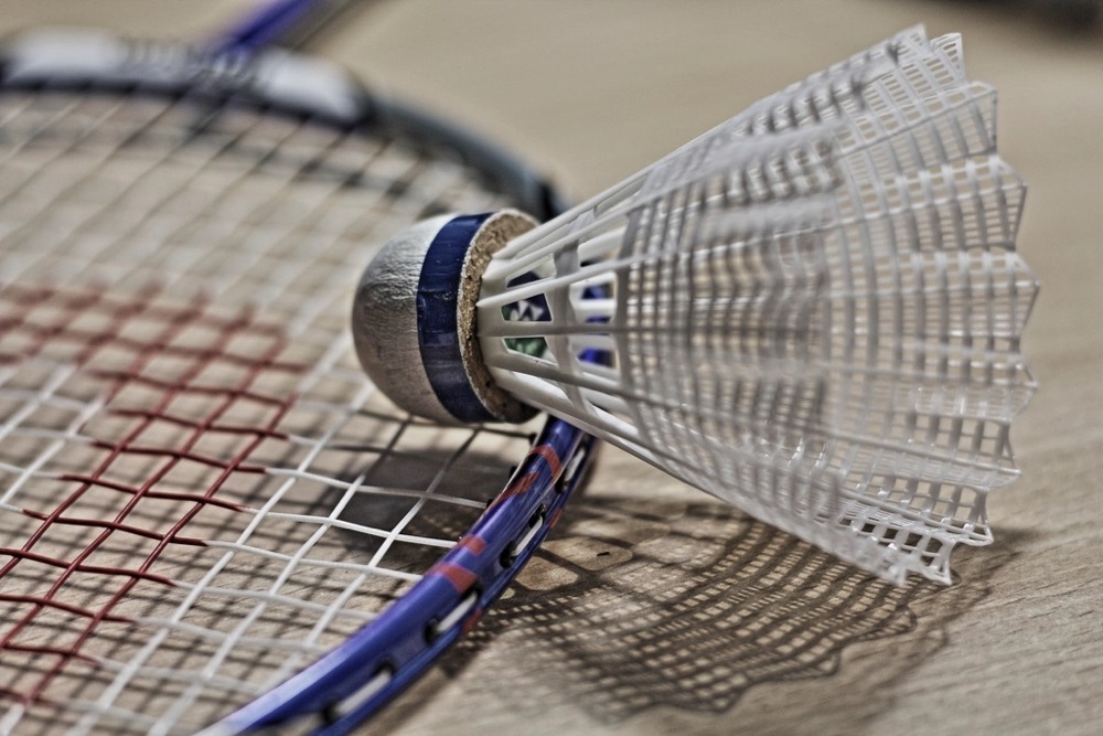 Shuttlecock resting on racket strings