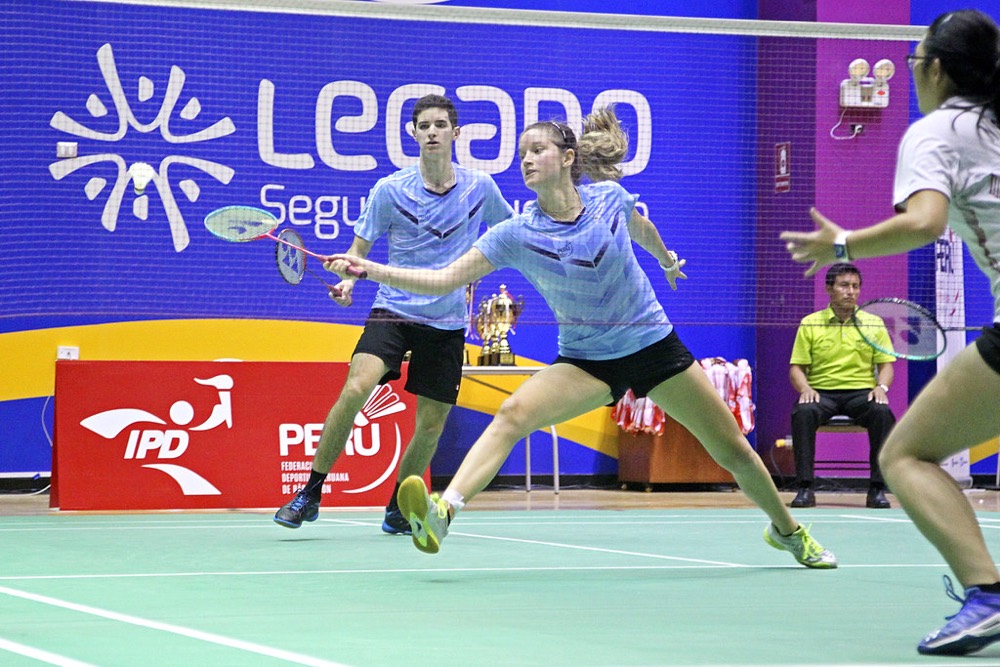 Mixed doubles pair lunging to play shots at the net